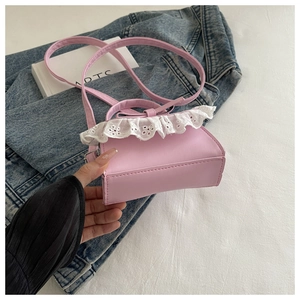 Dettaglio della mini borsa rosa con bordo in pizzo bianco e un dolce fiocco decorativo
