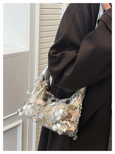 Detailed view of silver sequin crescent underarm bag with metallic reflective texture