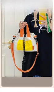 Détail du sac cabas en toile color-block avec fermeture à cordon et poche jaune