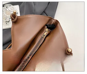 Detail view of smooth zipper closure and inner pocket of the brown leather tote bag