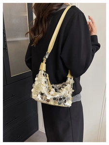 Detail of shimmering champagne sequins and adjustable yellow strap on the shoulder bag