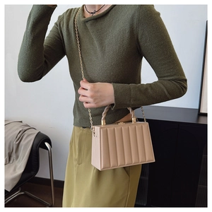 Close-up of beige crossbody bag with vertical pleated texture and gold chain strap