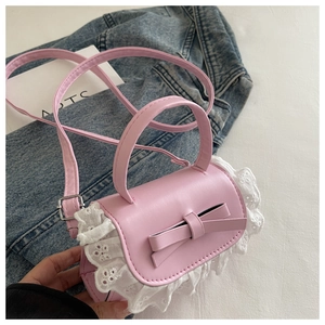 Detailed view of pink mini crossbody bag with a 3D bow and white lace embroidery trim