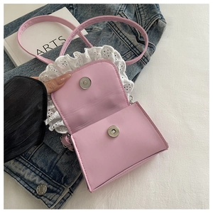 Detailed view of pink mini crossbody bag with white lace trim and double magnetic clasps