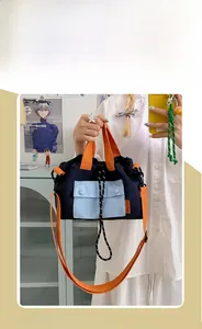 Détail du sac fourre-tout en nylon avec bretelles orange et poches bleues contrastées