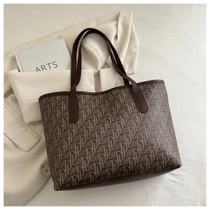 Vue détaillée de dessus d'un grand sac cabas marron à imprimé sur un blazer beige élégant