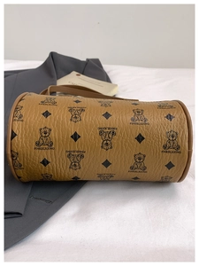 Detailed view of the tan pebble leather cylinder bag with bear pattern and strap