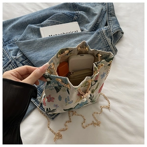 Floral embroidery bucket bag showing interior space for phone, wallet and lipstick