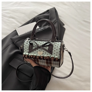Detail of canvas plaid bag with mint star print, ruffled trim and leather bow accent