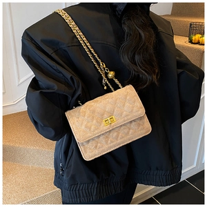 Detail of beige quilted chain bag with gold twist lock on a black jacket style