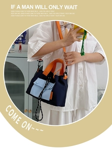 Détail du sac fourre-tout en nylon avec poches bleues et poignées orange contrastées