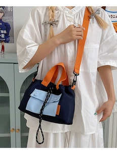 Détail du cabas en toile avec poignées orange et bandoulière réglable pour le porté