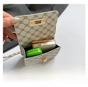 Detail view of mini crossbody bag interior showing storage space for makeup and gold chain