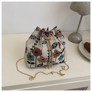 Detail of floral jacquard bucket bag with gold chain drawstring and pearl charms