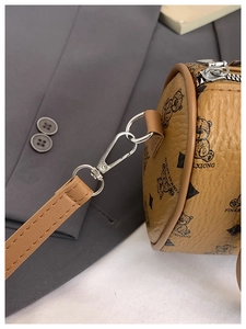 Close-up of the vintage teddy bear print and silver metal hardware on a brown boston bag