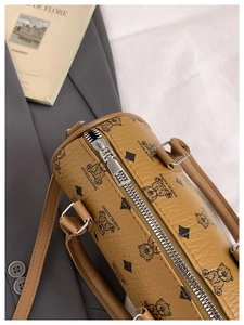 Close-up of brown leather Boston bag with cartoon bear print and silver zipper