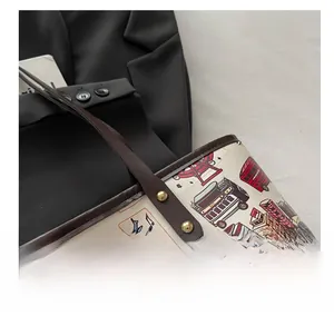 Détail du sac cabas à motifs urbains avec bandoulière en cuir brun et rivets dorés