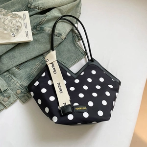 Chic black tote bag with white polka dots and woven strap for autumn commuting style