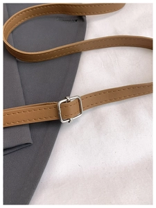 Detail of adjustable brown leather shoulder strap with silver buckle and fine stitching