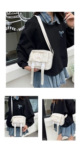 Three-way view of small cream-colored messenger bag with buckle straps and fabric label