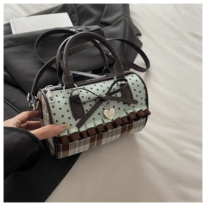 Detail of blue star pattern and plaid bag featuring bow decor and heart tag