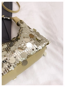 Detail of champagne gold sequin handbag showing metallic texture and faux leather trim
