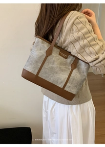 Detail shot of a large retro tote bag in gray canvas with brown leather trim details