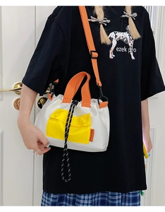 Détail du sac fourre-tout color-block avec poche jaune et bandoulière orange réglable