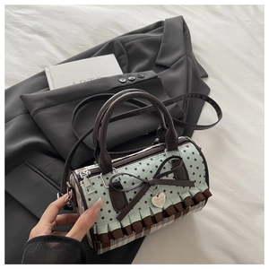Detail of canvas plaid bag showing mint green star print and brown bow heart pendant