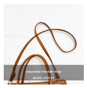 Detail view of the brown leather tote featuring adjustable shoulder straps and gold buckles