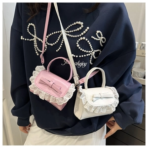 Close-up of sweet lace trim and bow detail on pink and white mini crossbody bags