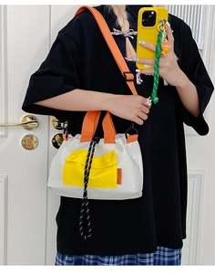 Détail du sac cabas stylé avec poche avant jaune vif et bandoulières orange vif