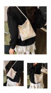 Detail of New Chinese style bucket bag with gold floral embroidery and grey tassel