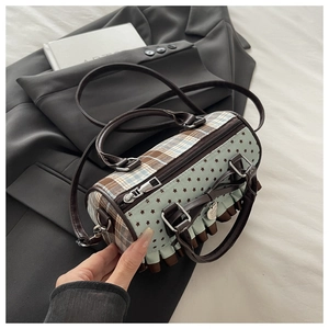 Detailed shot of bow-style cylindrical crossbody bag featuring plaid and star patterns