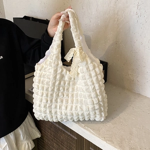 Sac fourre-tout blanc texturé à bulles avec nœud en dentelle beige et style minimaliste