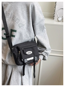 Detail of black nylon messenger bag with buckle closures and adjustable shoulder strap