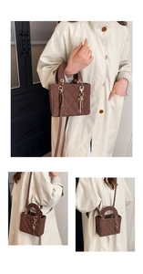 Detail of brown quilted faux leather tote with golden key charm and crossbody strap