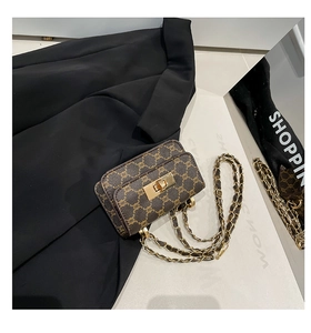 Detail of vintage monogram leather crossbody bag with gold twist lock on black blazer