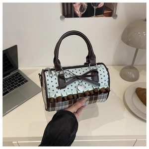 Detail of blue star pattern boston bag with brown bow and plaid texture accents