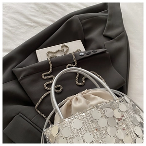 Detail of silver sequin bucket bag with drawstring liner and round metallic handle