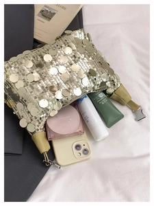 Macro view of golden sequin shoulder bag detailing metallic buckle and fabric strap