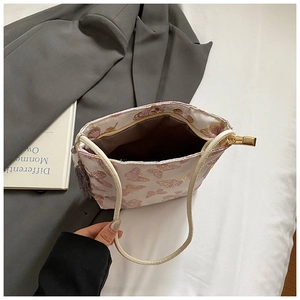 Detail of cream tote bag with pink butterfly prints and internal capacity showing zipper