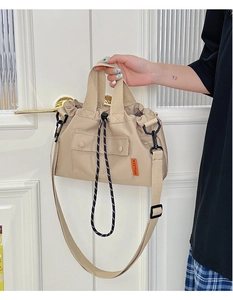 Détail d'un cabas en nylon beige avec fermeture à cordon et bandoulière réglable