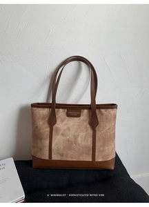 Macro detail of the color-block tote bag featuring canvas texture and leather handles