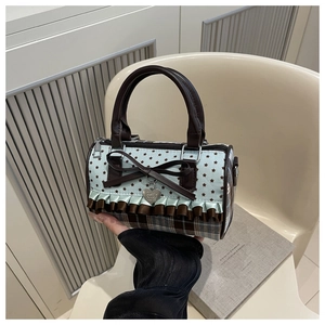 Close-up of a sweet Boston bag featuring blue star patterns, plaid fabric and bow detail
