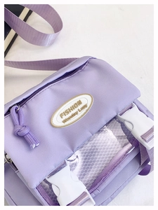 Detail of light purple nylon messenger bag with transparent mesh pocket and white buckles
