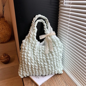 Mint green pleated tote bag with white lace bow detail shown on a rustic windowsill