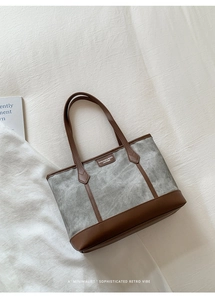 Close-up of vintage tote bag detail with leather logo and canvas texture