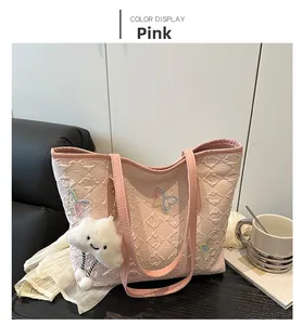 Detail of pink tote bag with quilted pattern, butterfly embroidery and plush charm
