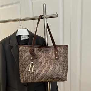 Brown monogram tote bag with leather handles and gold metal R pendant for daily work commute